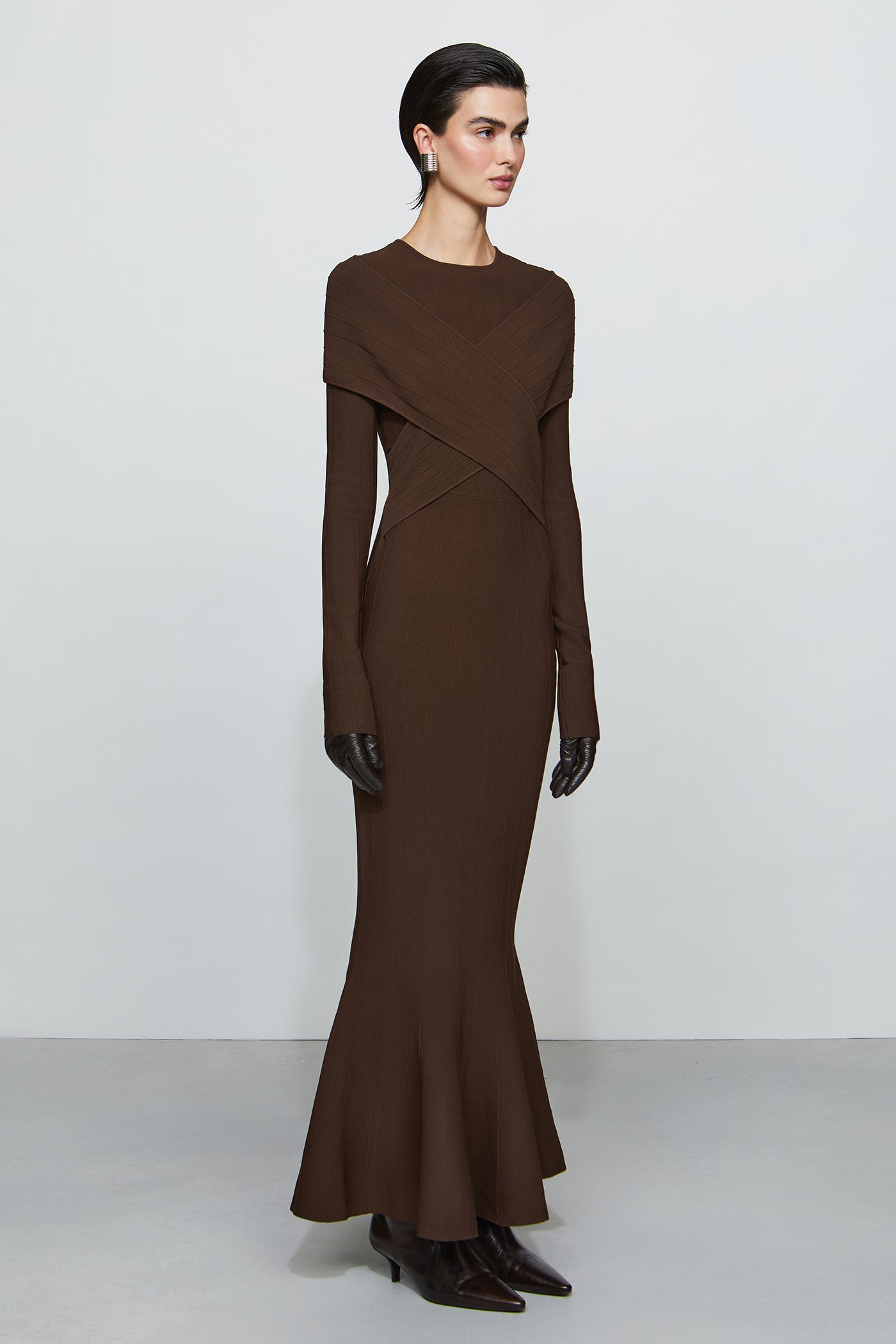 Woman wearing a brown long-sleeve dress against a white background