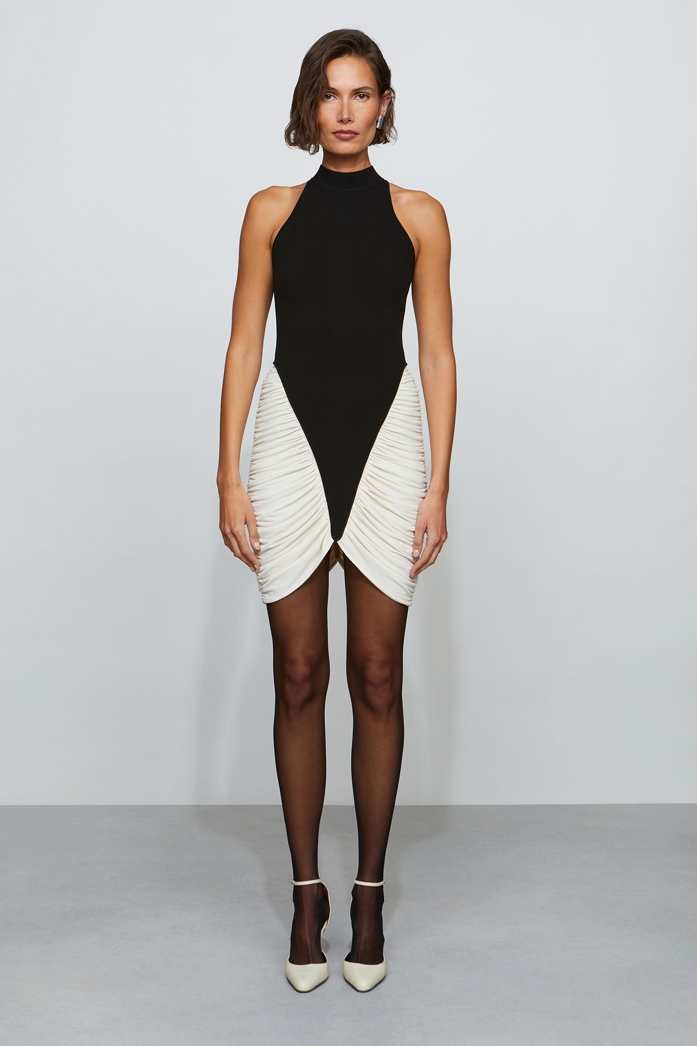 Woman wearing a black and white dress on a plain background