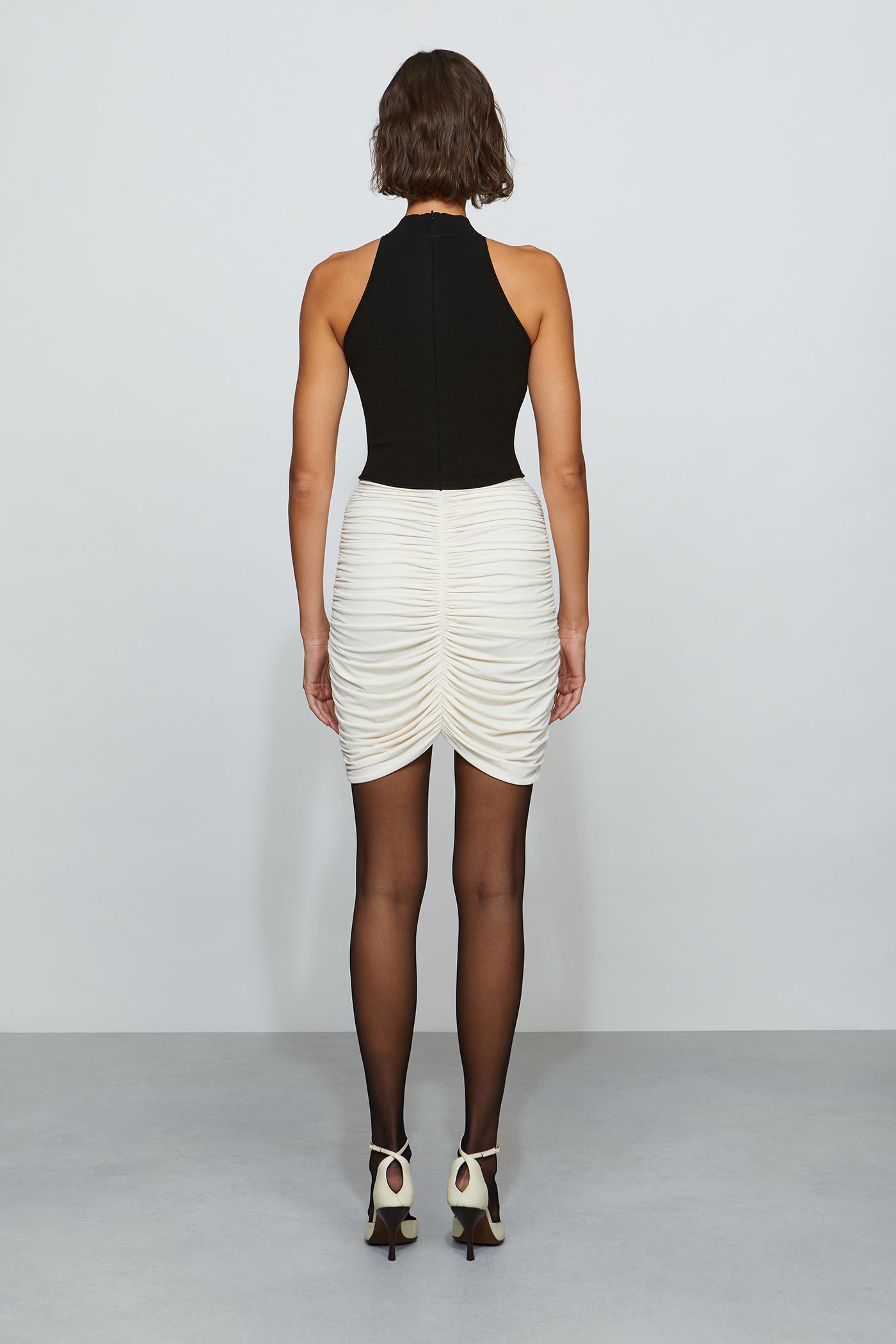 Woman wearing a black and white dress on a plain background