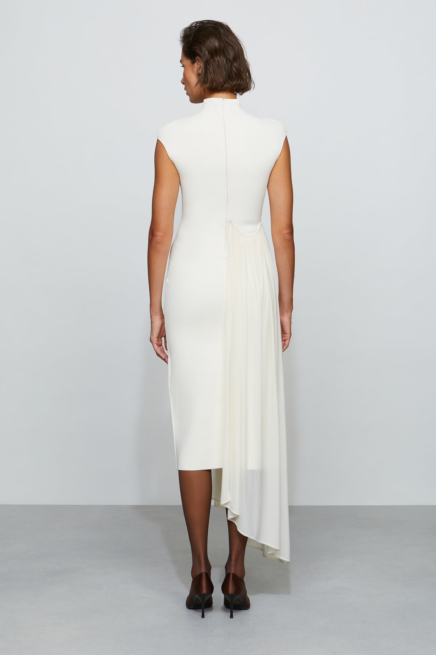 Woman wearing a white dress with a plain background