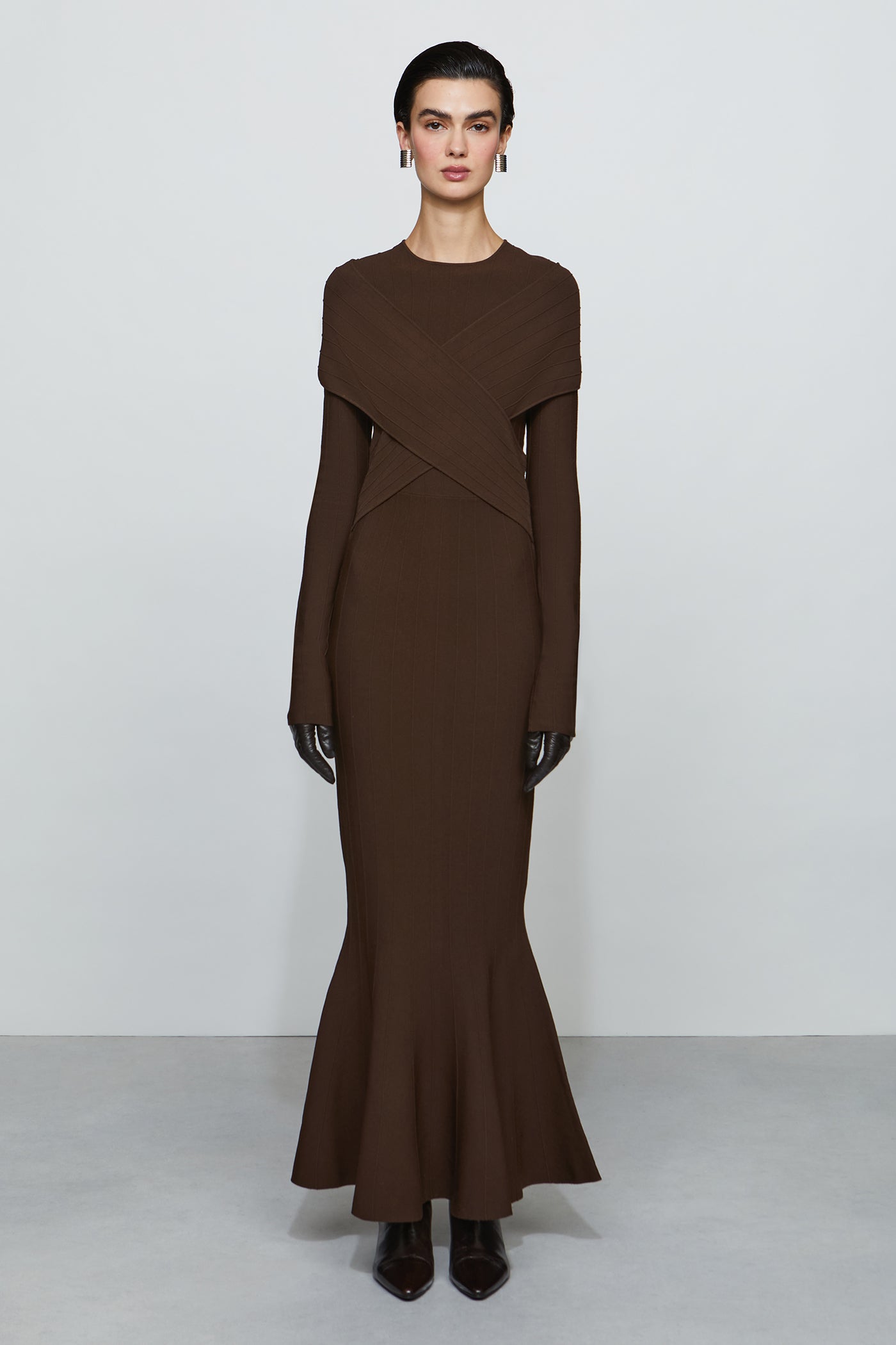 Woman wearing a brown dress with a plain background