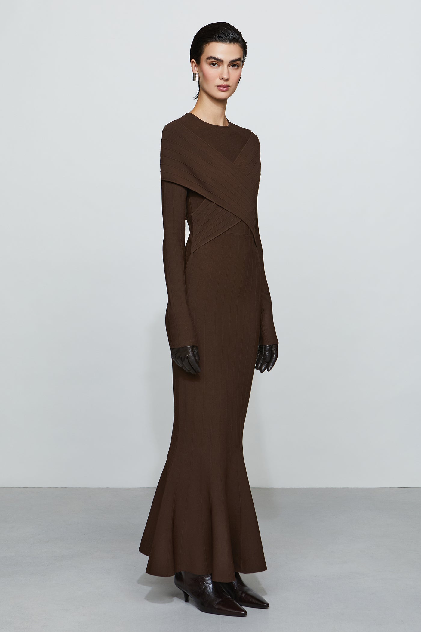 Woman wearing a brown dress with a plain background