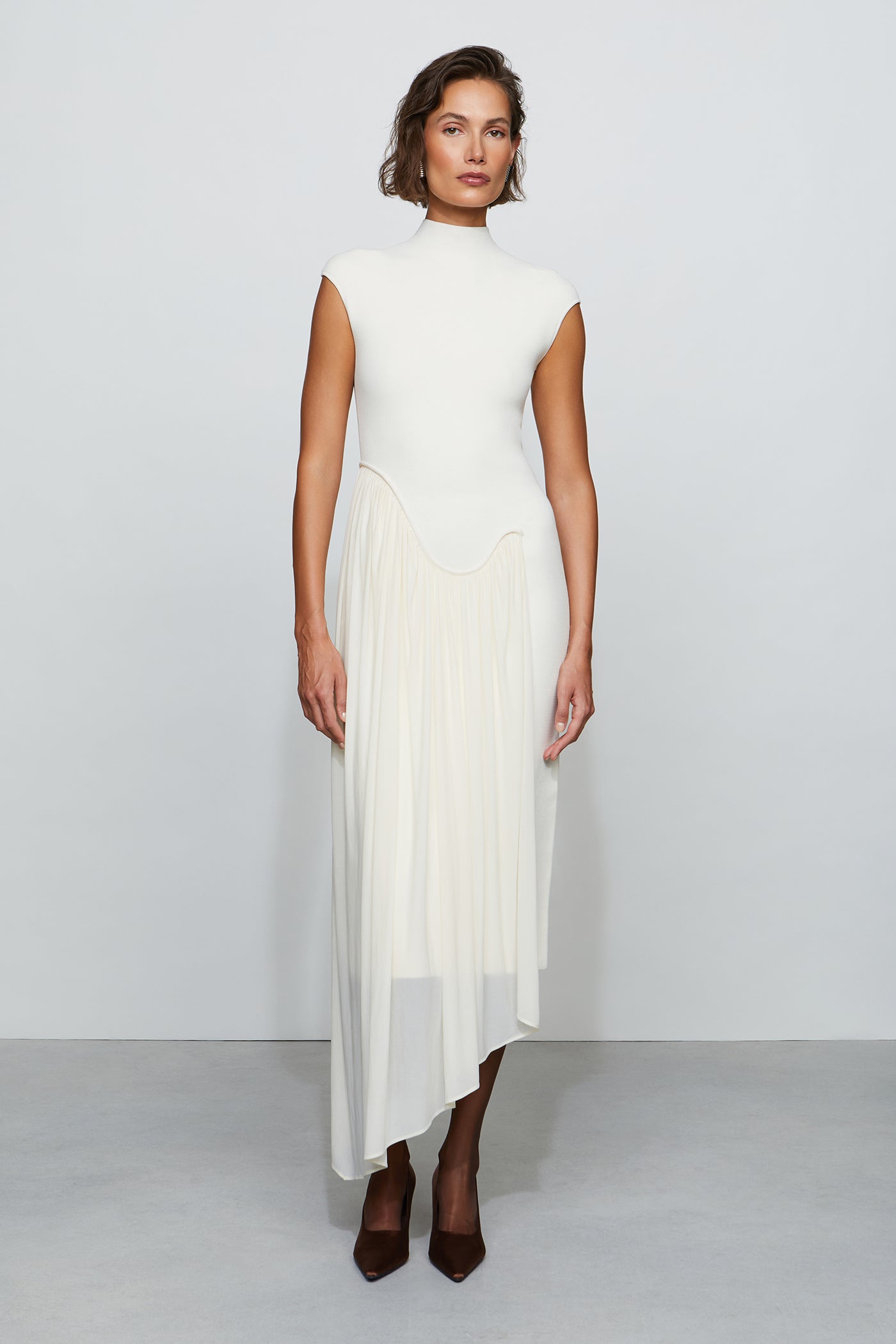 Woman wearing a white dress with a plain background