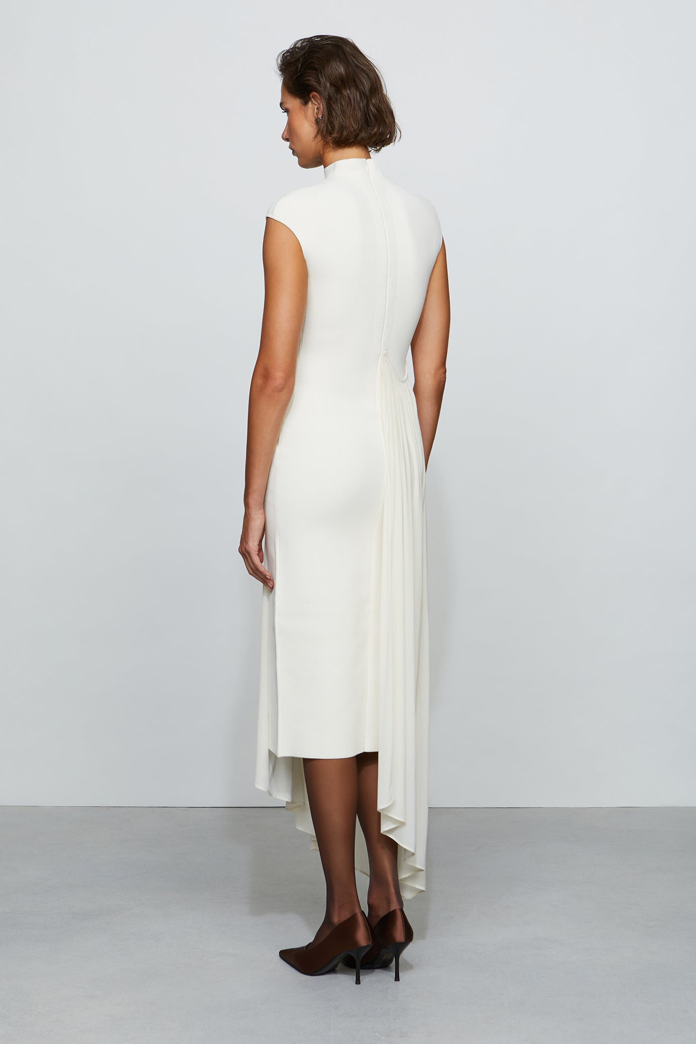 Woman wearing a white dress with a plain background