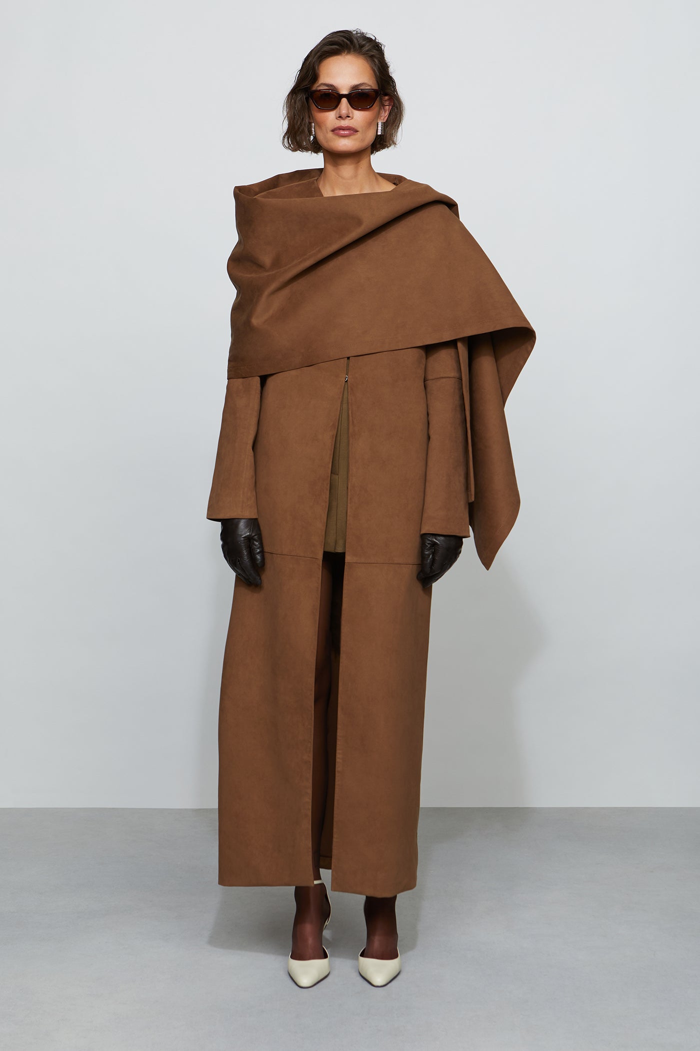 Woman wearing a brown coat with a white background