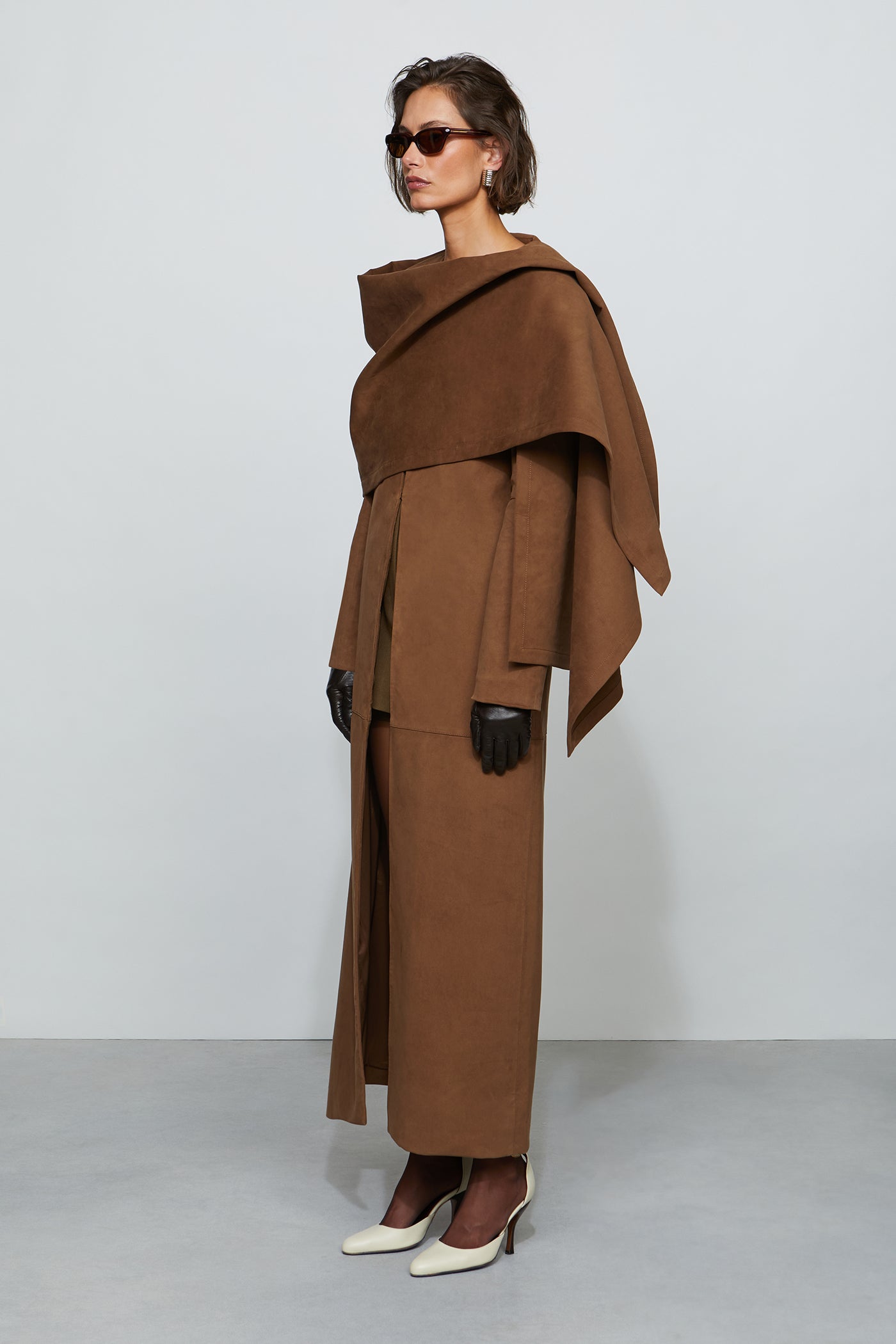 Woman wearing a brown coat with a plain background